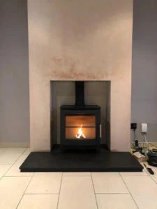 A Boxed & Lipped Honed Granite Hearth into an open fireplace